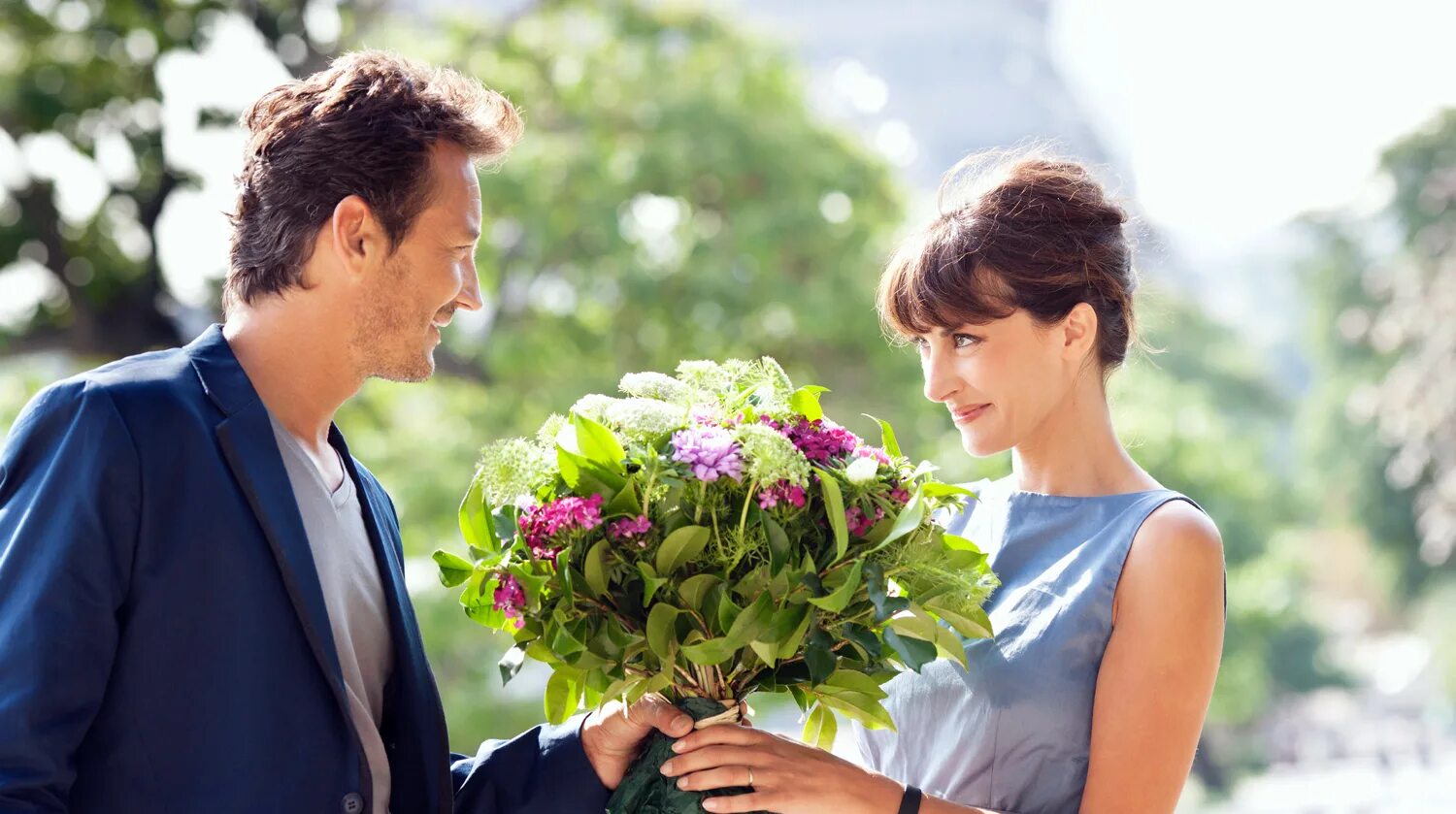 Этикет свиданий. Парень дарит девушке цветы. Мужчина дарит цветы женщине. Мужчина дарит букет цветов. Парень даёт девушке цветы.