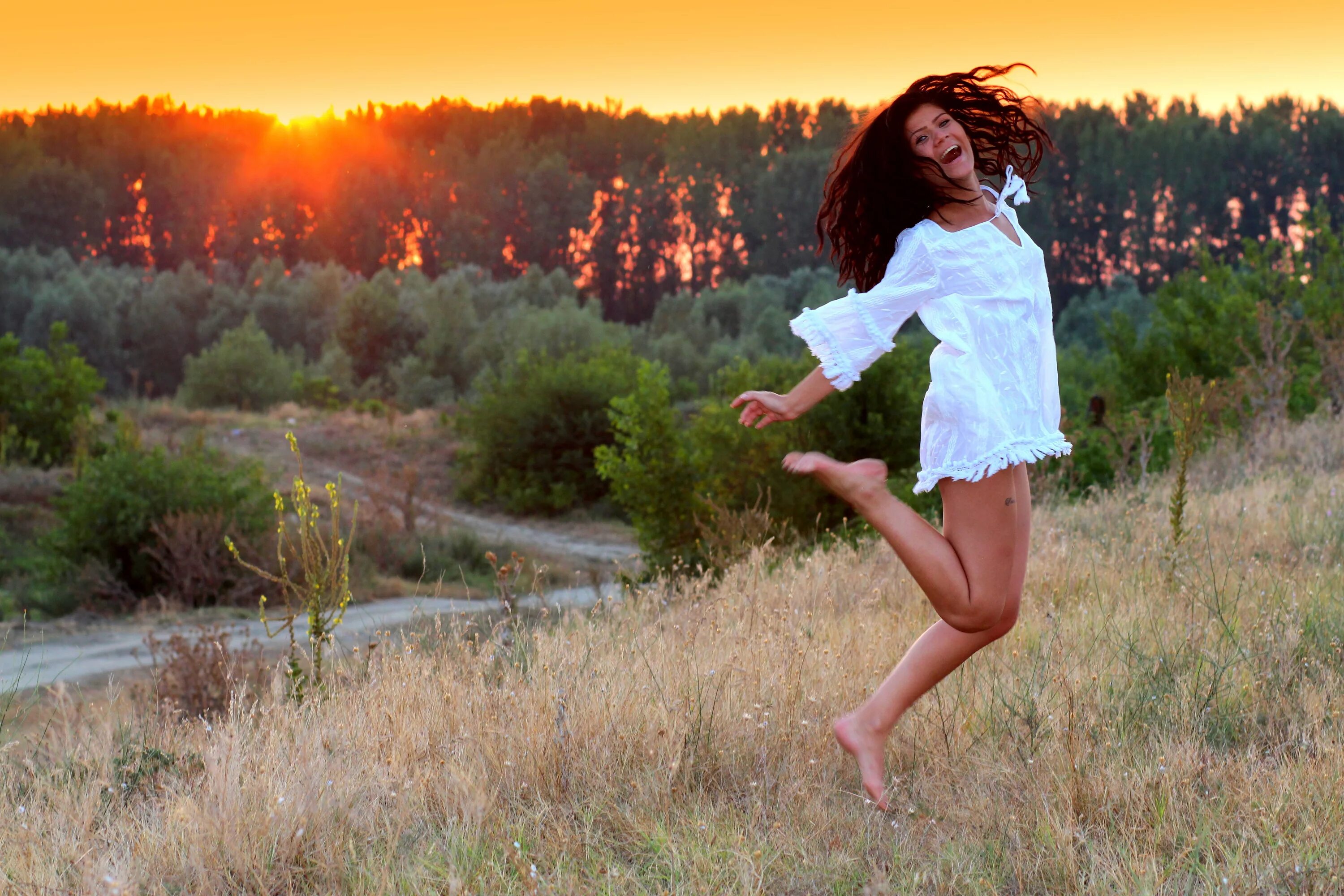 Мамаша прыгает. Девушка бежит в платье. Девушка в прыжке. Счастливая девушка. Счастливая девушка на природе.