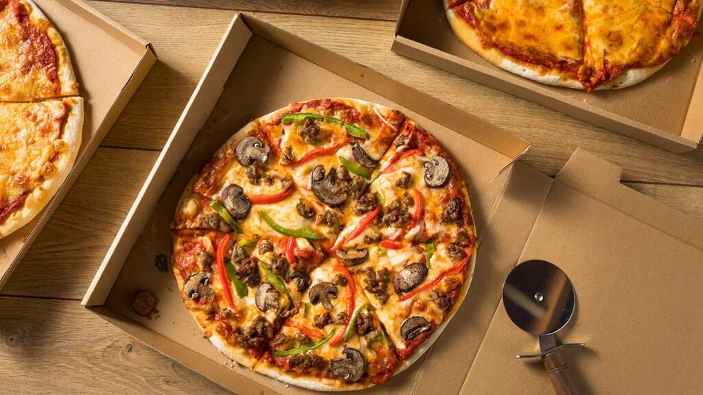 Пицца в коробках. Коробка для пиццы. Коробка пиццы на столе. Квадратная пицца в круглой коробке. Почему пицца круглая а коробка