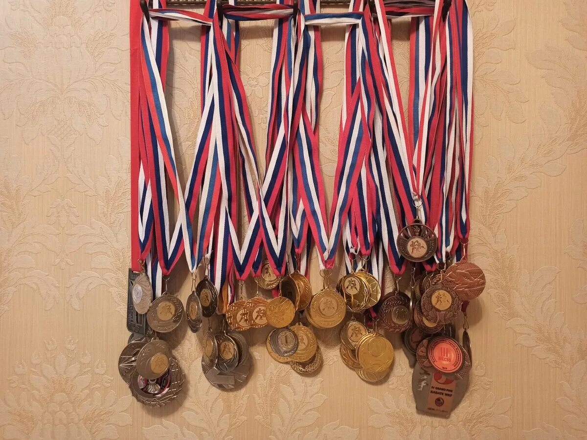 Медали спортивные. Много медалей на стене. Много медалей по боксу. Спортивные награды.