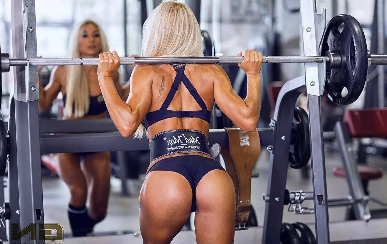 красивые ягодицы в спортзале. ягодицы со штангой. обратные выпады в тренажере смита. приседания со штангой. приседания в тренажере смита.