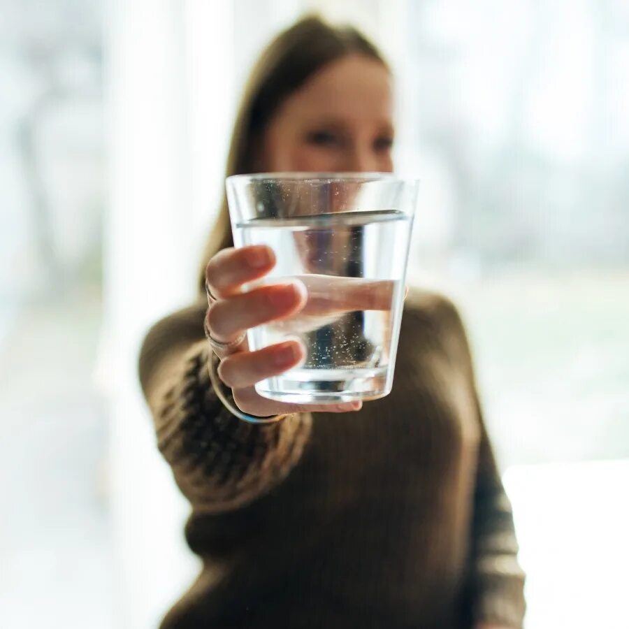 Пить воду после пробуждения. Стакан воды. Девушка со стаканом воды. Человек пьет из стакана. Стакан теплой воды.