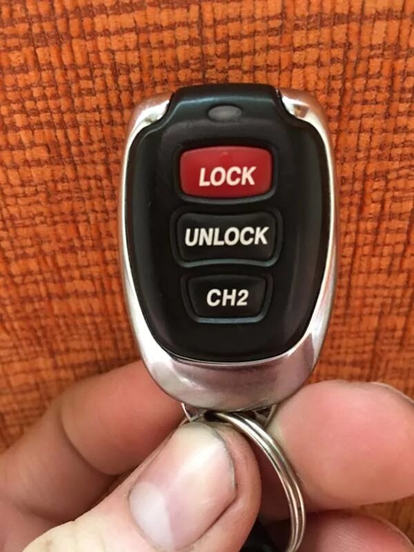 Брелок с красной кнопкой. Брелки автосигнализации Lock Unlock ch2. Land Cruiser 100 2 кнопочный брелок. Пульт сигнализации 2 кнопки. Брелок с кнопками Lock Unlock Ch 2.