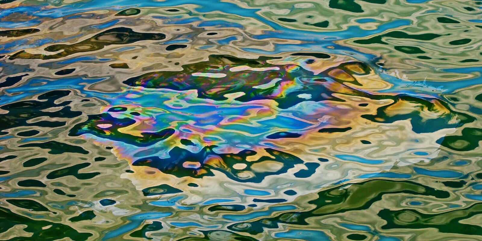 Масляная пленка на воде. Нефтяная пленка на воде. нефтяная плёнка на поверхности воды. бензиновая пленка на воде.