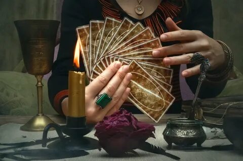 1. A fortune teller holding and hands a deck of tarot cardsCredit. 