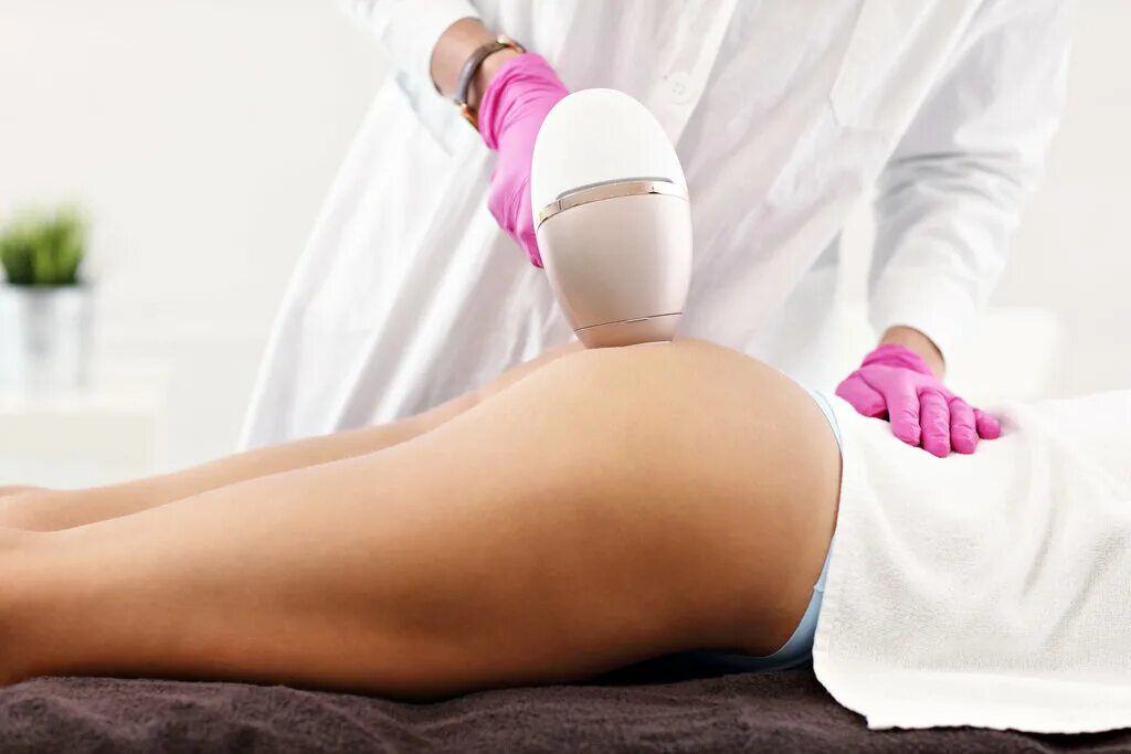 Эпиляция ягодиц. Фото девушки на песочном пляже в шортах с руками на попе. Девушка держит джинсы. Каста наир индия удаление волос. Removing butt.