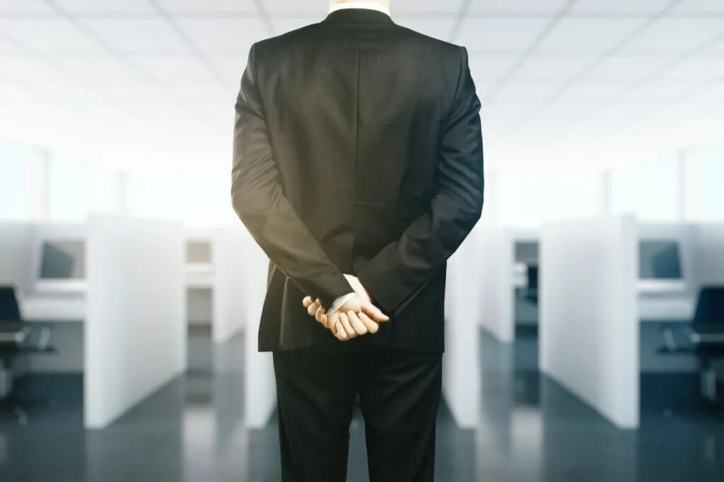 Behind position. Behind back. arms behind back. man in suit arm behind back. body language cross hands.