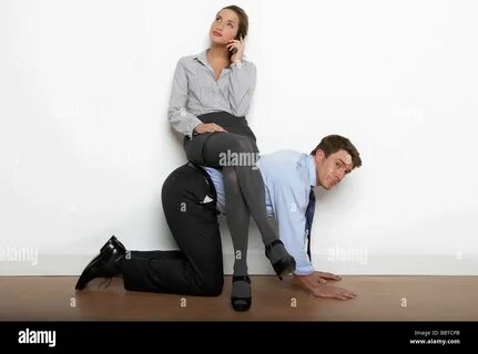 Business woman sitting on man's back Stock Photo - Alamy.