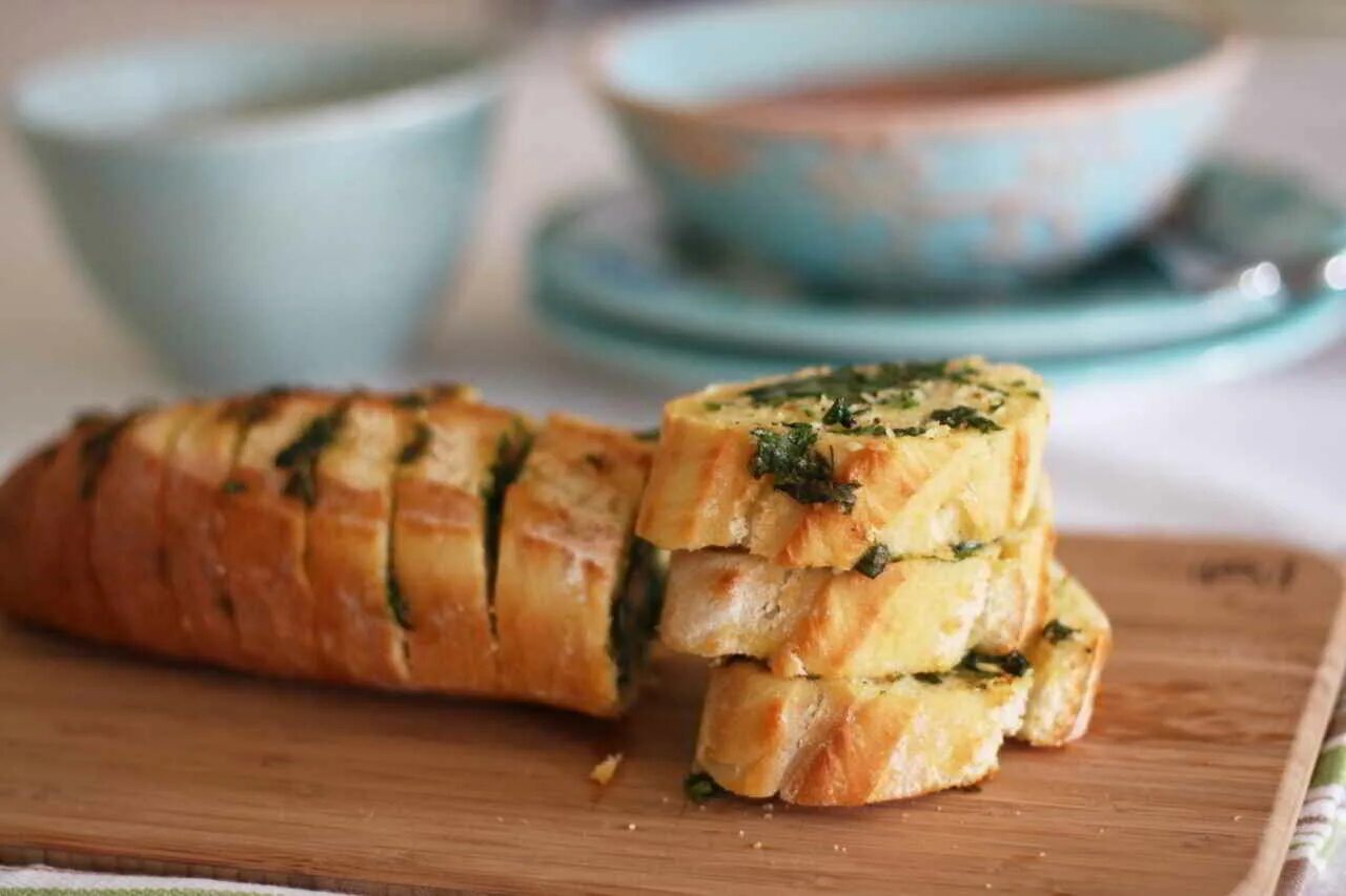 Рецепт багет сыром чесноком. Хлеб с чесноком и зеленью. Закусочный хлеб с сыром и чесноком. Чесночный хлеб с сыром. Багет с чесноком и зеленью в духовке.