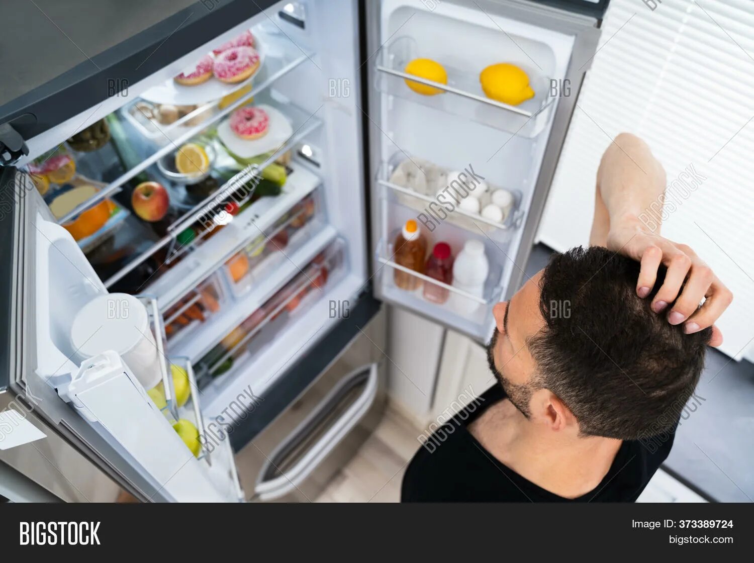 Look in the fridge. Man opening fridge open.