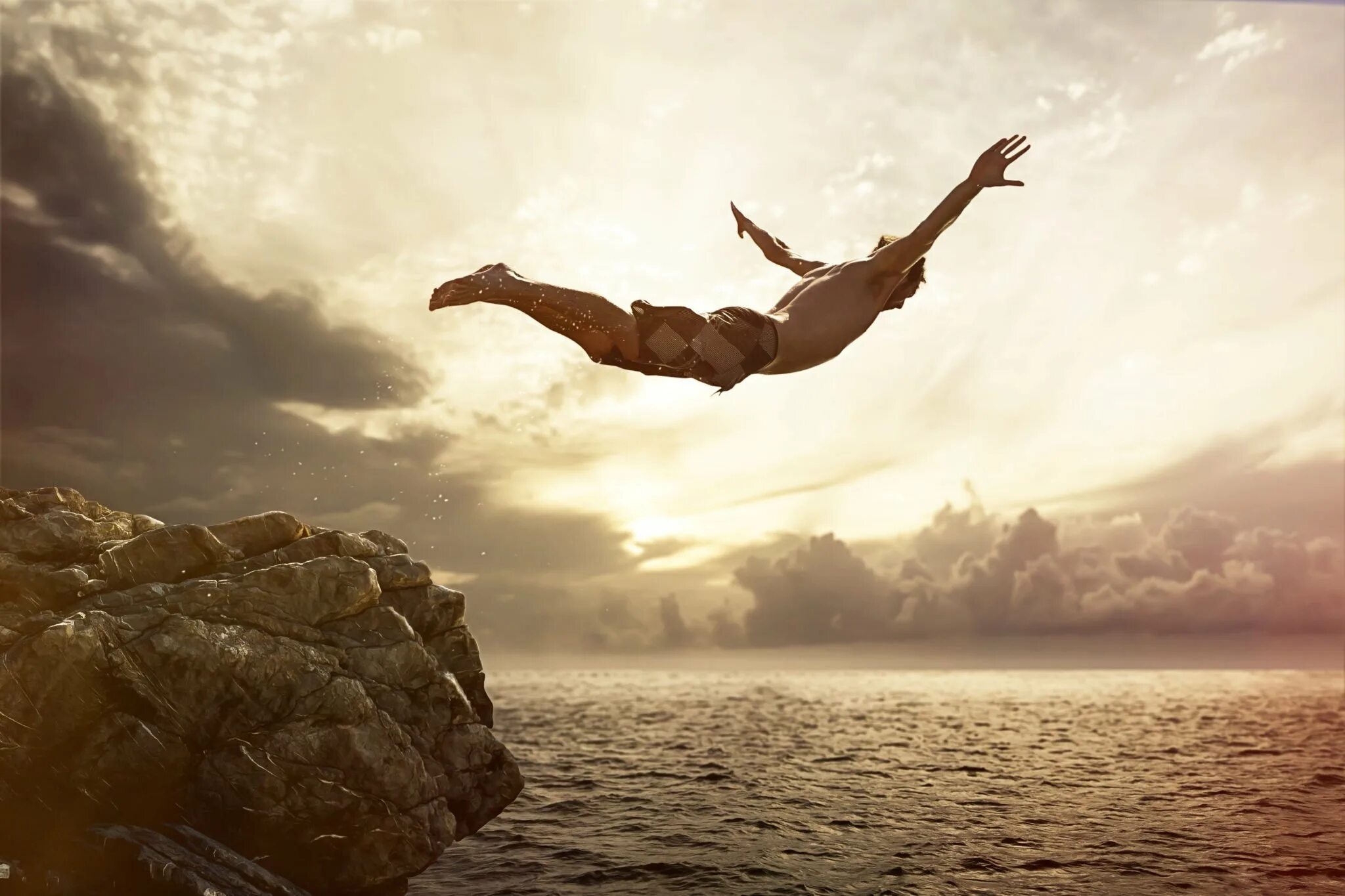 Свобода. Человек прыгает со скалы. Прыжок с обрыва. Прыжок с обрыва в море. Полет в прыжке.