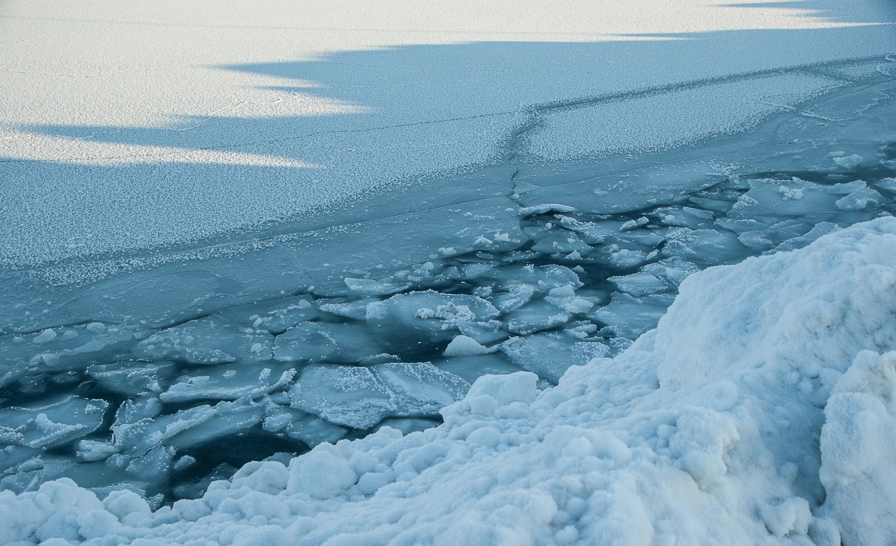 Вода покрыта льдом. Северный Ледовитый океан замерзает. Лед на реке. Лед под снегом. Лед на озере.