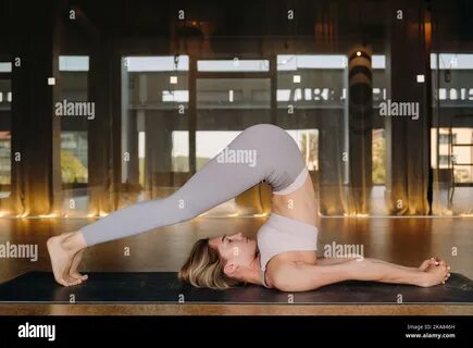 A woman in sports clothes does yoga exercises in the gym Stock Photo. 