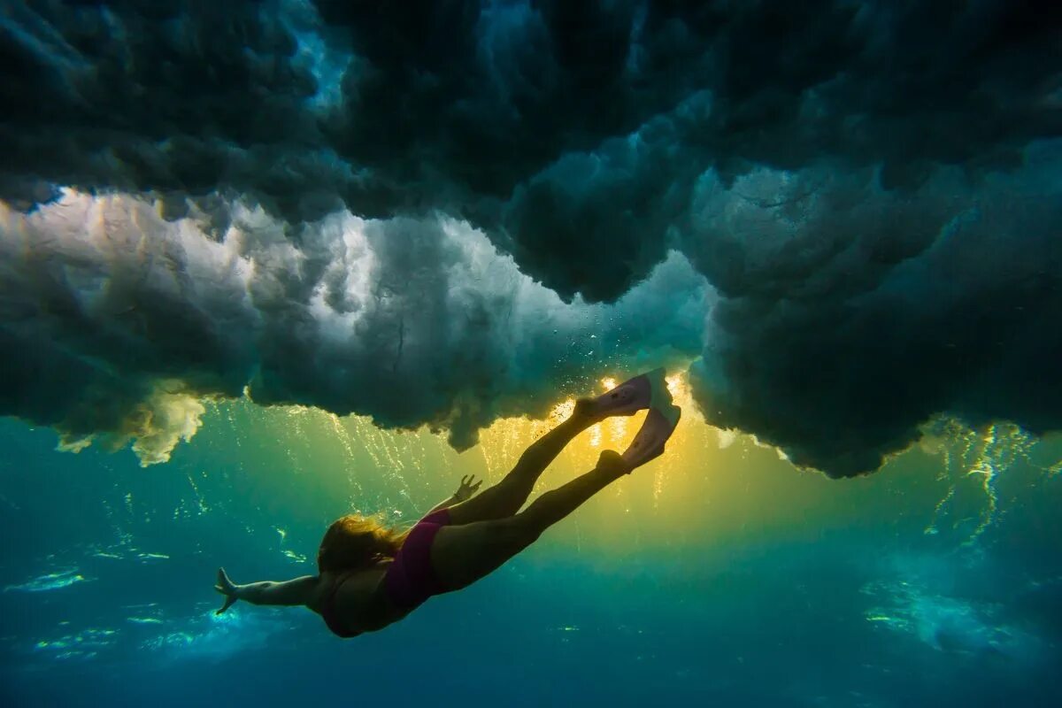 Душевная глубина. Погружение в воду. Девушка ныряет в океан. Ныряние под воду. Человек под водой.