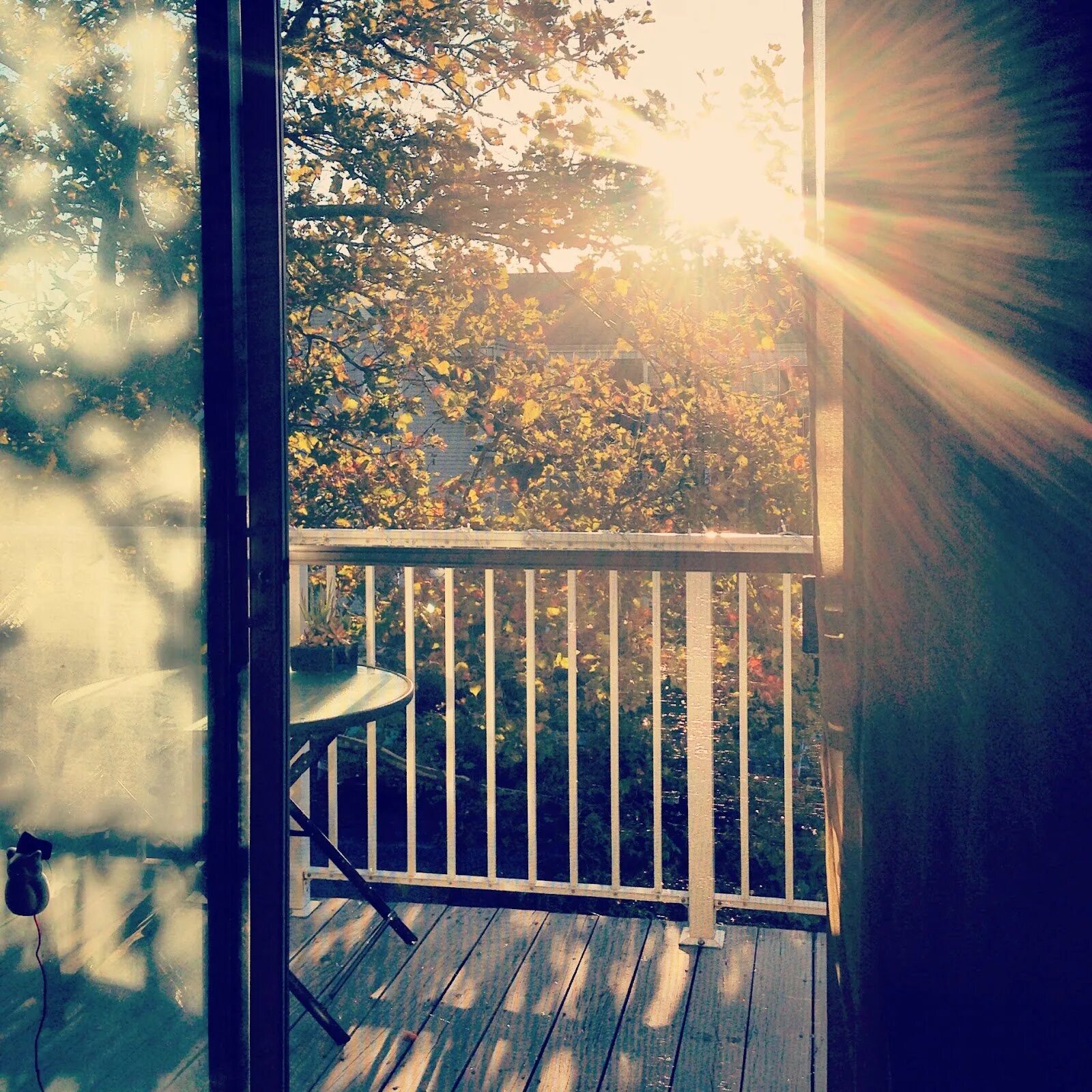 Теплый и солнечный город. Солнце в окне. Луч солнца в окне. Солнечное утро в окне. Солнечные лучи в окне.