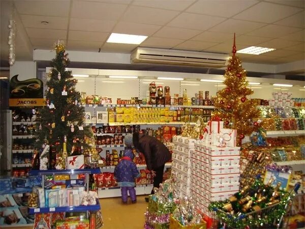 новогодний магазин. новогодние продукты в магазине. новогодняя ярмарка. новогодний ассортимент. прилавки елочных игрушек.