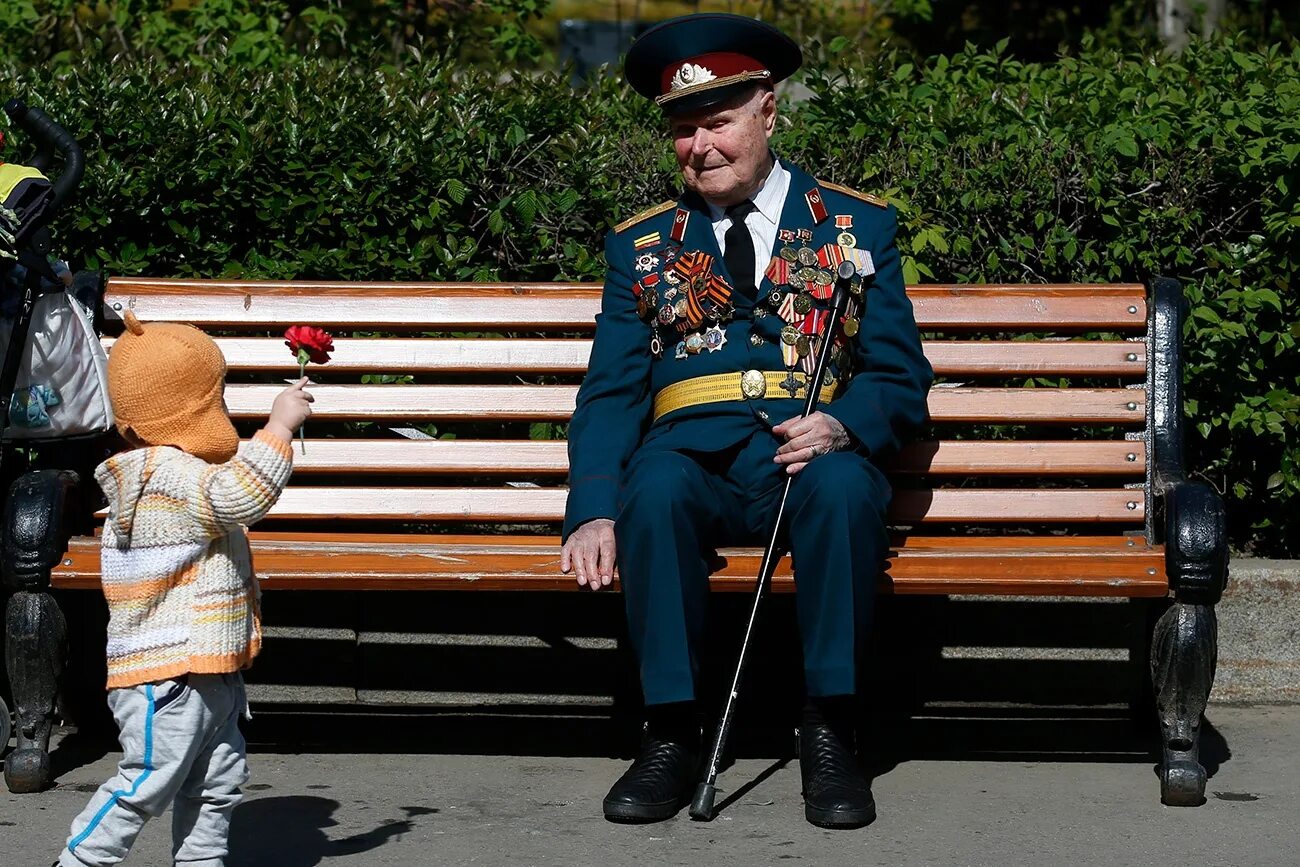 Идти на встречу с ветераном. Ветеран на лавочке. Ветеран сидит на скамейке. Ветераны с внуками на параде. Дед ветеран и внук.