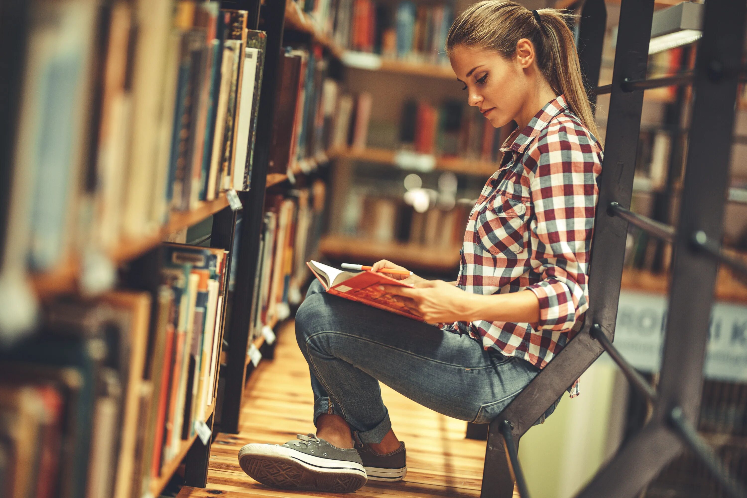 She reads magazines. Студенты в библиотеке. Студент с книгами. Чтение книг. Девушка с книгой.