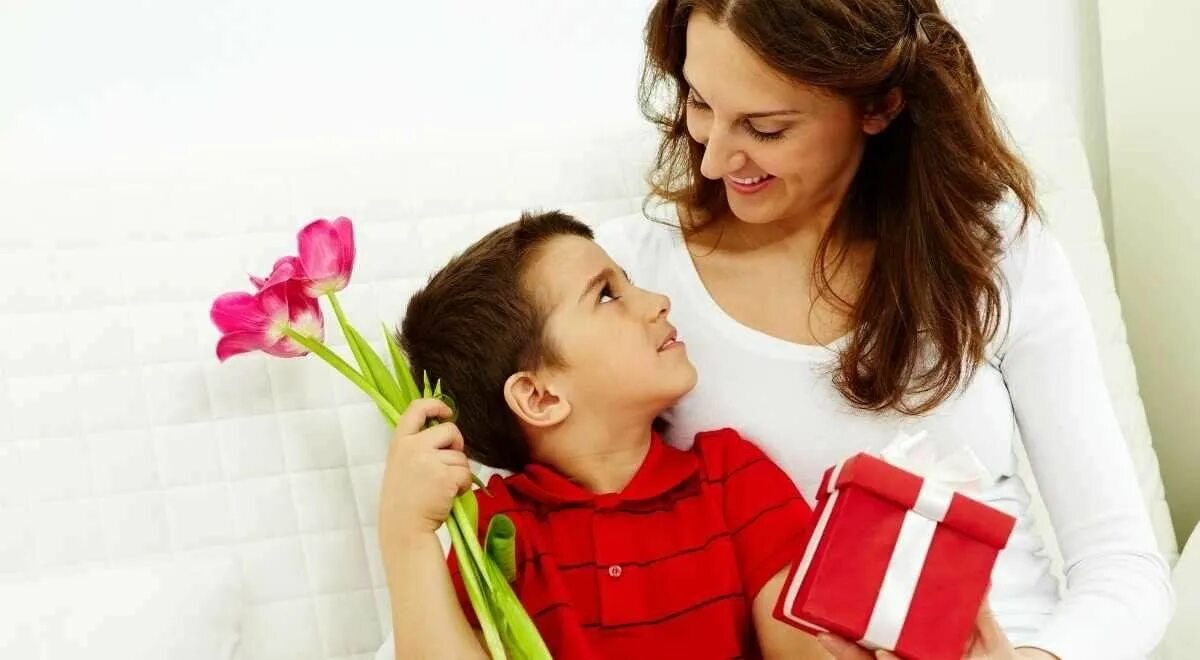 Ребенок дарит цветы маме. Ребенок дарит подарок маме. День матери. Дети поздравляют маму. Праздник для мам и девочек