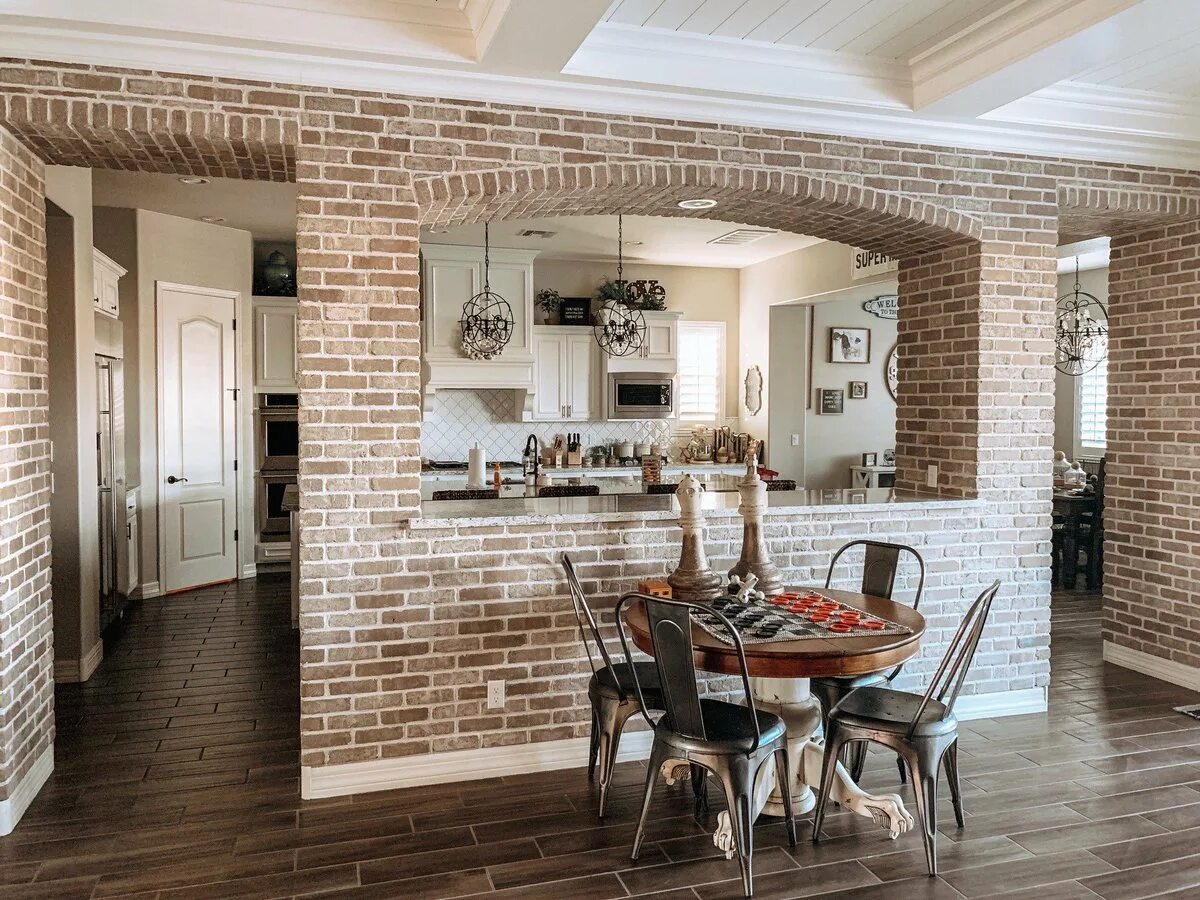 Кирпич на балку. Кирпич в интерьере. Кирпич на балку. Кухня гостиная с балками на потолке. Колонна из кирпича в интерьере.