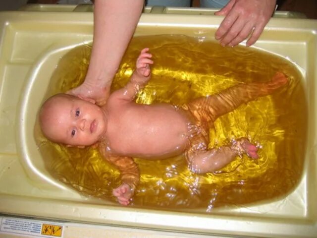 Купание новорожденного ребенка. Лечебные ванны для новорожденных. Ванна с ромашкой для грудничка. Купание грудного ребенка.