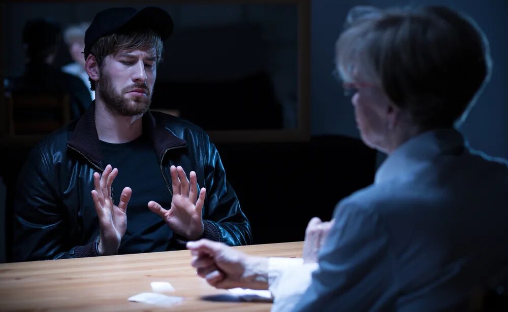 The police are questioning him. Detective questioning a man. policemen question a suspect. junky man.