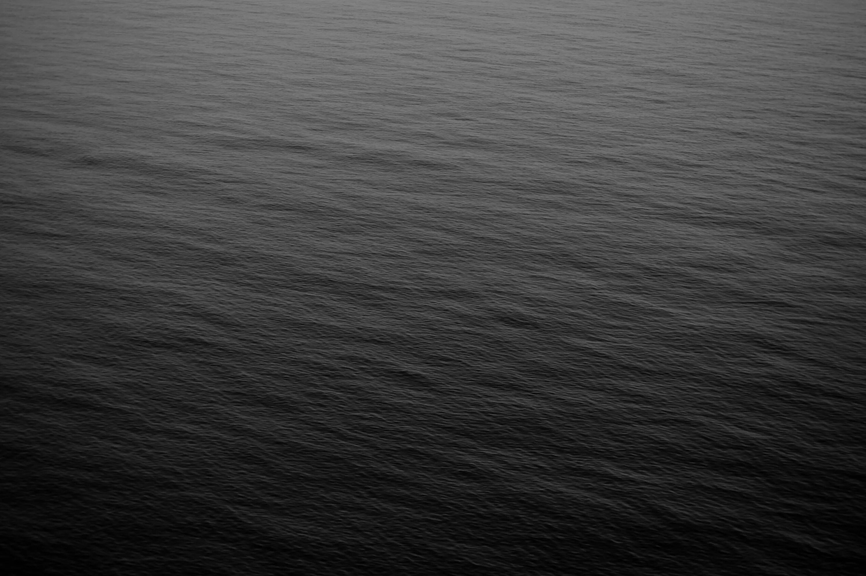 Черная вода далеко. Темная текстура. Темные воды. Море черного цвета. Темный фон.