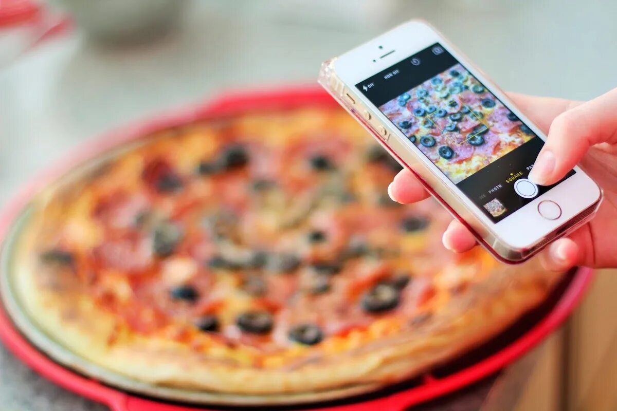 Телефон заказ роллы. Фотографирует пиццу. Телефон и еда. Фотографирование еды. Фотографирует еду.