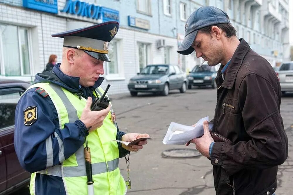 Полицейский штрафует. ДПСНИК штрафует. Полицейский проверяет документы.