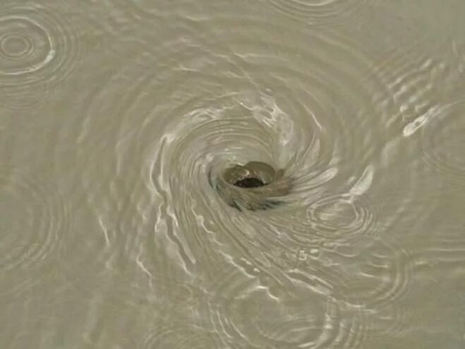 Воронка в воде. Раковина с водой. Воронка воды в раковине. Закрученная струя воды. Водоворот в раковине.