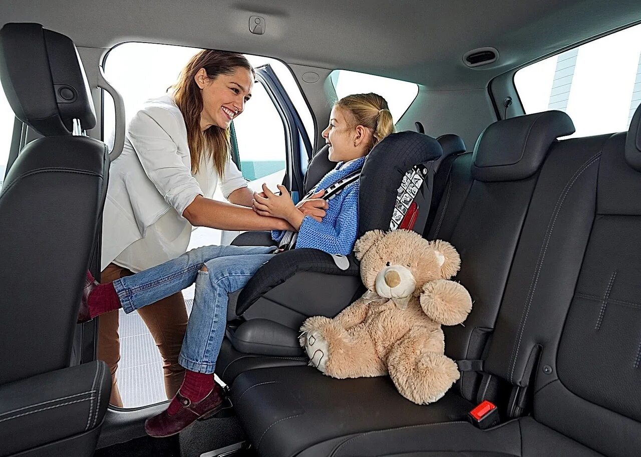 Безопасность в машине на заднем сиденье. Автоняня. Женщина с ребенком в автомобиле. Автомобиль для детей. Детское кресло минивэны.