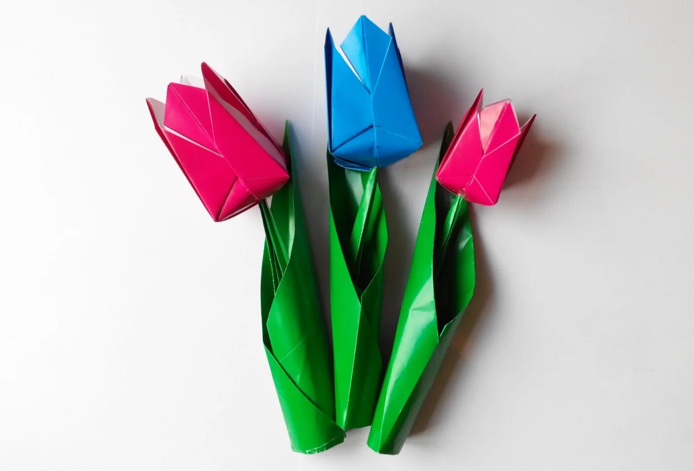 2 поделки оригами. Оригами тюльпан. Тюльпан оригами чашелистик. Тюльпаны из цветной бумаги. Поделка тюльпаны из бумаги.
