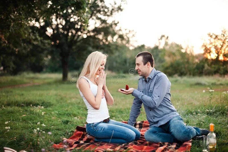 Предложение на пикнике. Поцелуй на пикнике. Мужчина делает предложение в парке. Парень с девушкой на пикнике.