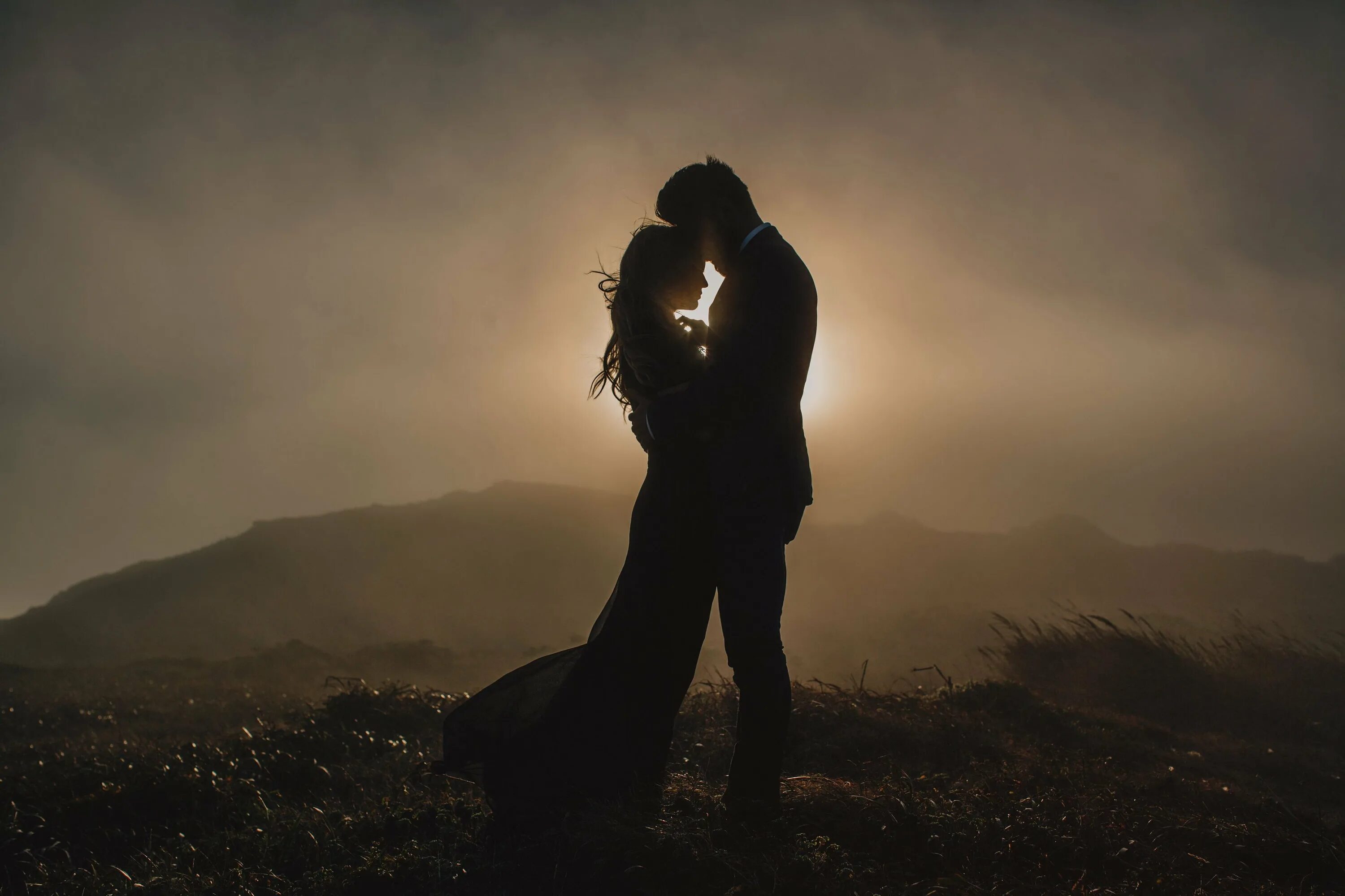 Двое над. Влюбленные в тумане. Мужчина и женщина со спины. Пара на обрыве. Пара обнимается со спины.