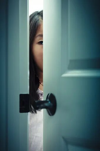 Девушка приоткрывает дверь. Девушка выглядывает из за двери. Человек за дверью. Смотрит через дверь
