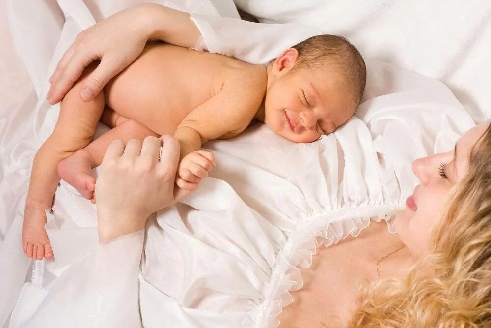 Младенец на руках. Женщина с младенцем. Девушка с новорожденным ребенком.