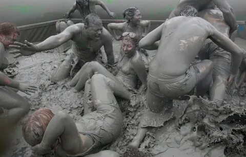 Festival goers wrestle in the mud during the Annual Boryeong Mud Festival a...