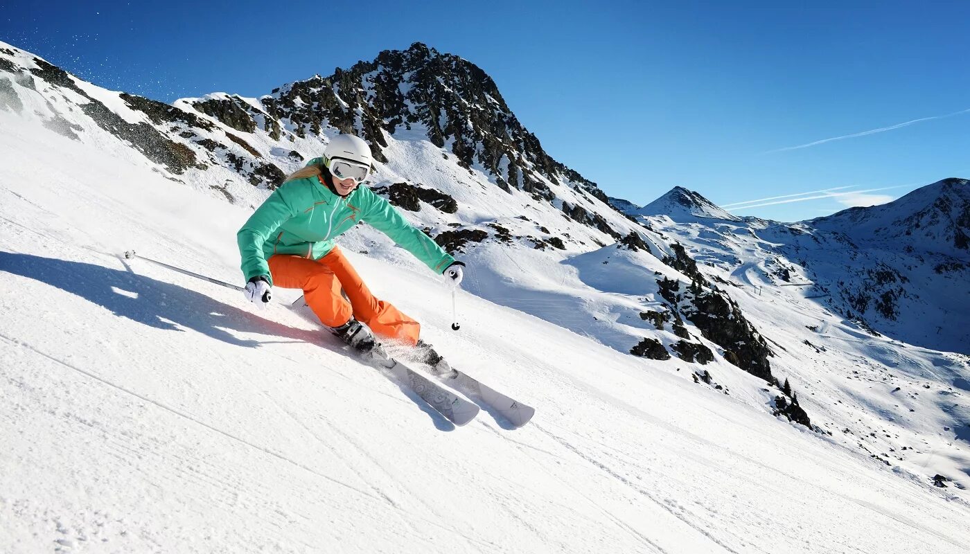 Горнолыжный спорт. Горные лыжи. Спуск на горных лыжах. Горнолыжник на склоне.