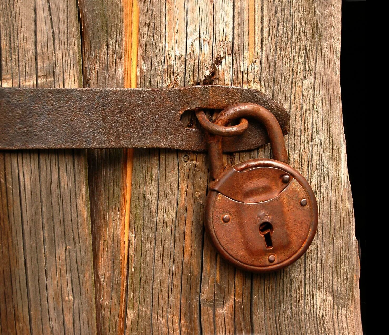 Старинная дверь. Амбарный замок на воротах. Заколоченная дверь замка. Дверь закрытая на замок. Замок навесной.