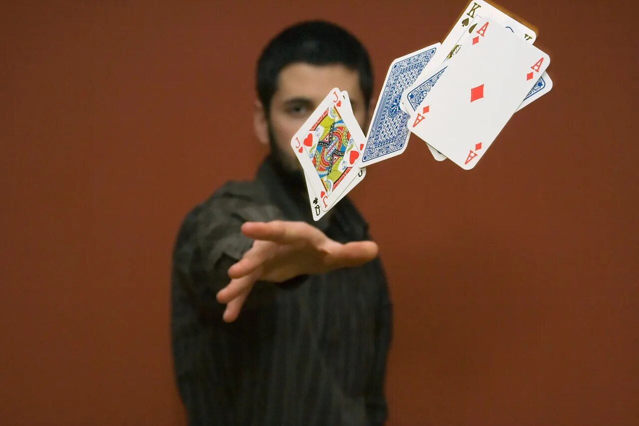 Бросает карты. Человек бросает карты. Карточный игрок. Мужчина с картами в руках. Какие карты кидать