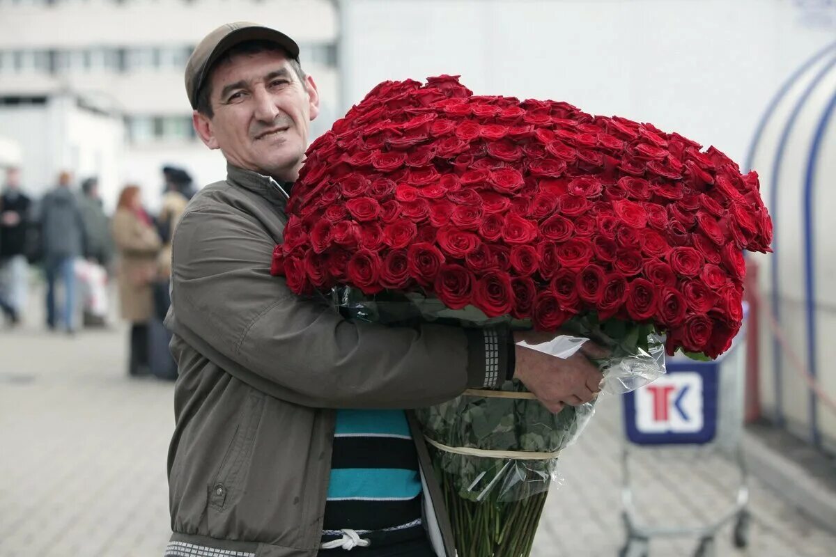 Уважение красный. Огромный букет цветов. Букет цветов для мужчины. Мужчина с цветами. Мужчина с огромным букетом.