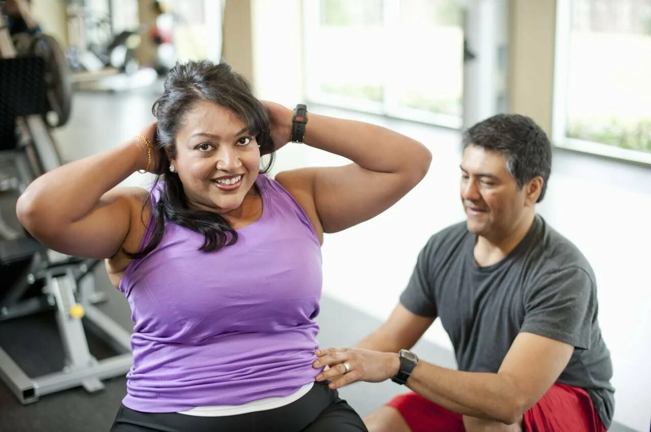 Фитнес для толстых. Тренировка полных людей. Люди в спортзале. Спортивная женщина с лишним весом. Толстая в тренажерном зале.