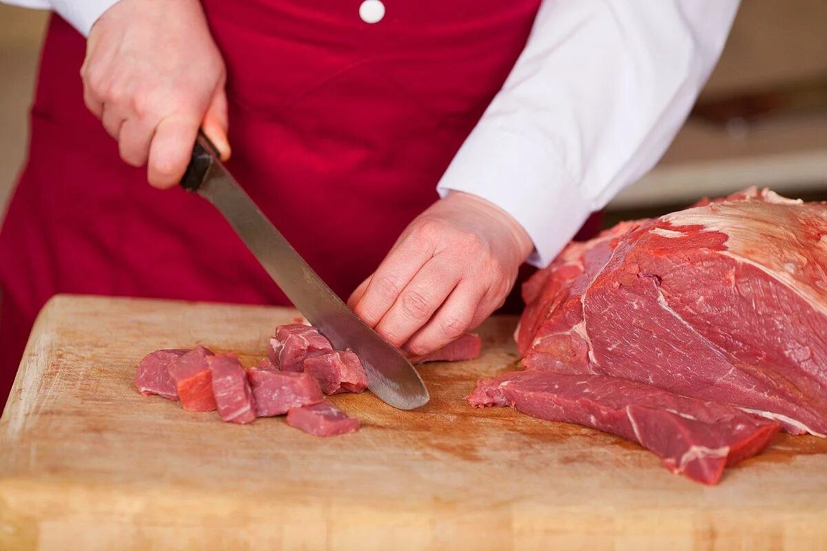 Нарезанное мясо. Нарезанное мясо на доске. Нож для мяса.