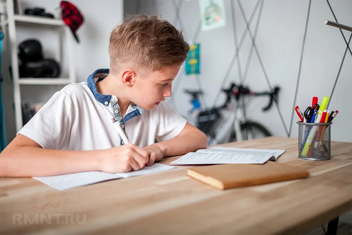Маленький ребенок делает уроки. Ребенок за письменным столом. Мальчик в школе. Школьник за письменным столом. Мальчик за столом.