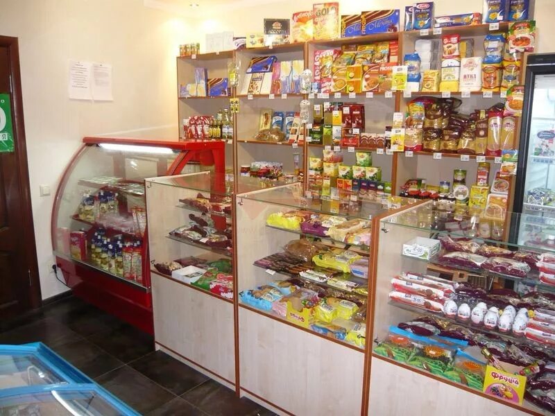 Продавец продуктов прилавочного типа. Выкладка товара в маленьком продуктовом магазине. витрина продуктового магазина. выкладка товара в небольшом продуктовом магазине. выкладка продуктов в маленьком магазине.