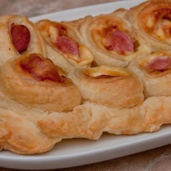 Пирожки из слоёного теста с сосисками. Пирог с сосисками. Сосиски в слоеном тесте пирогом. Сосиски в тесте с сыром. Пирог из сосисок в слоеном тесте.