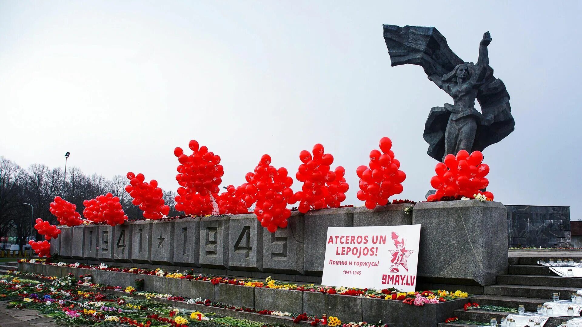 9 мая в латвии. Цветы на памятник. памятник освободителям риги. день победы в латвии. цветы к памятнику на 9 мая.