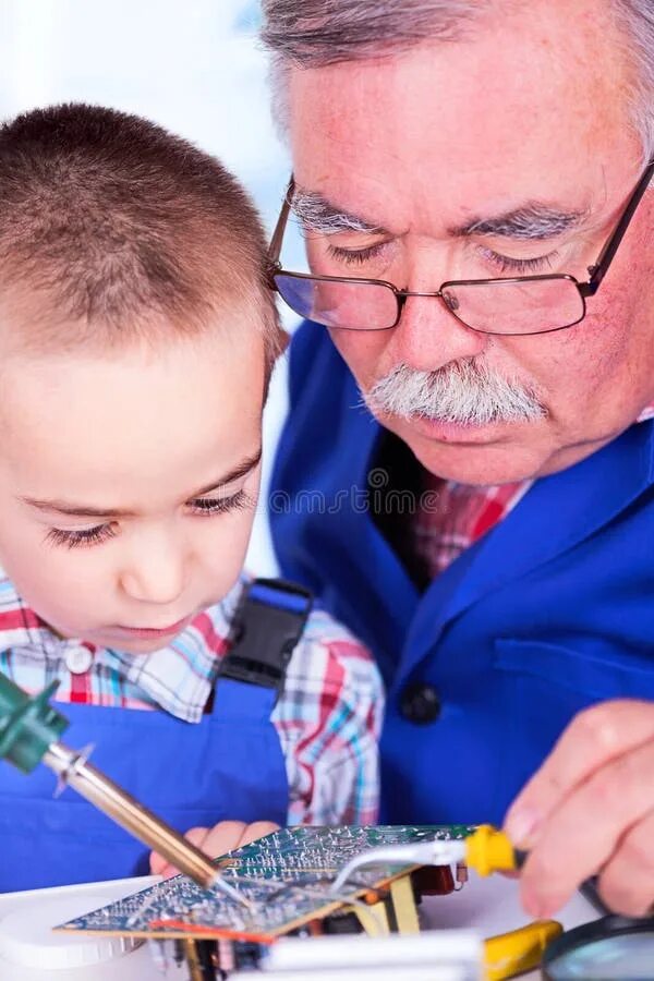 Дедушка учит внука. Дедушка чинит игрушку внуку. Дед с внуком в мастерской. Дед учит уроки с внуком.