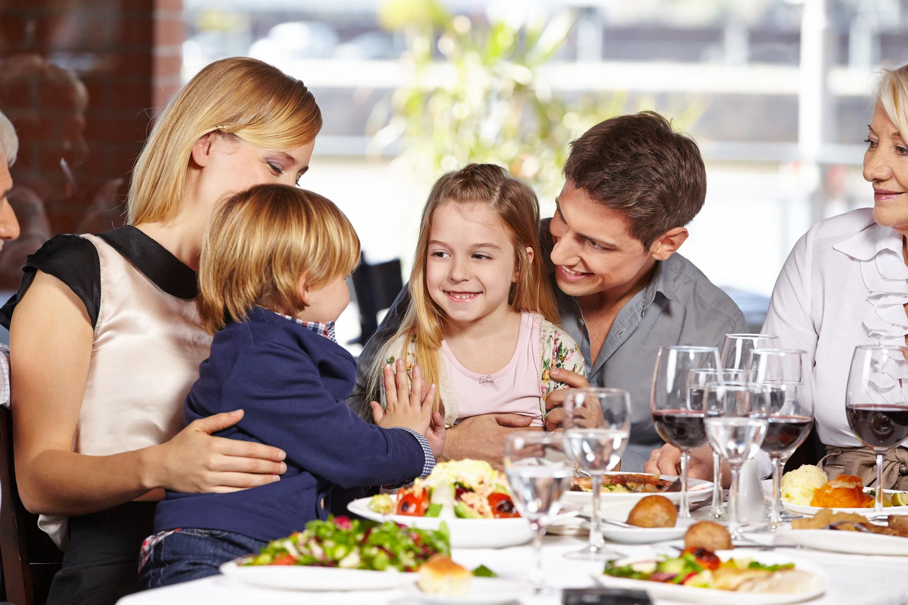 Friends dining. Семья за столом. Семейный обед. Семья в кафе. Семья обедает в ресторане.