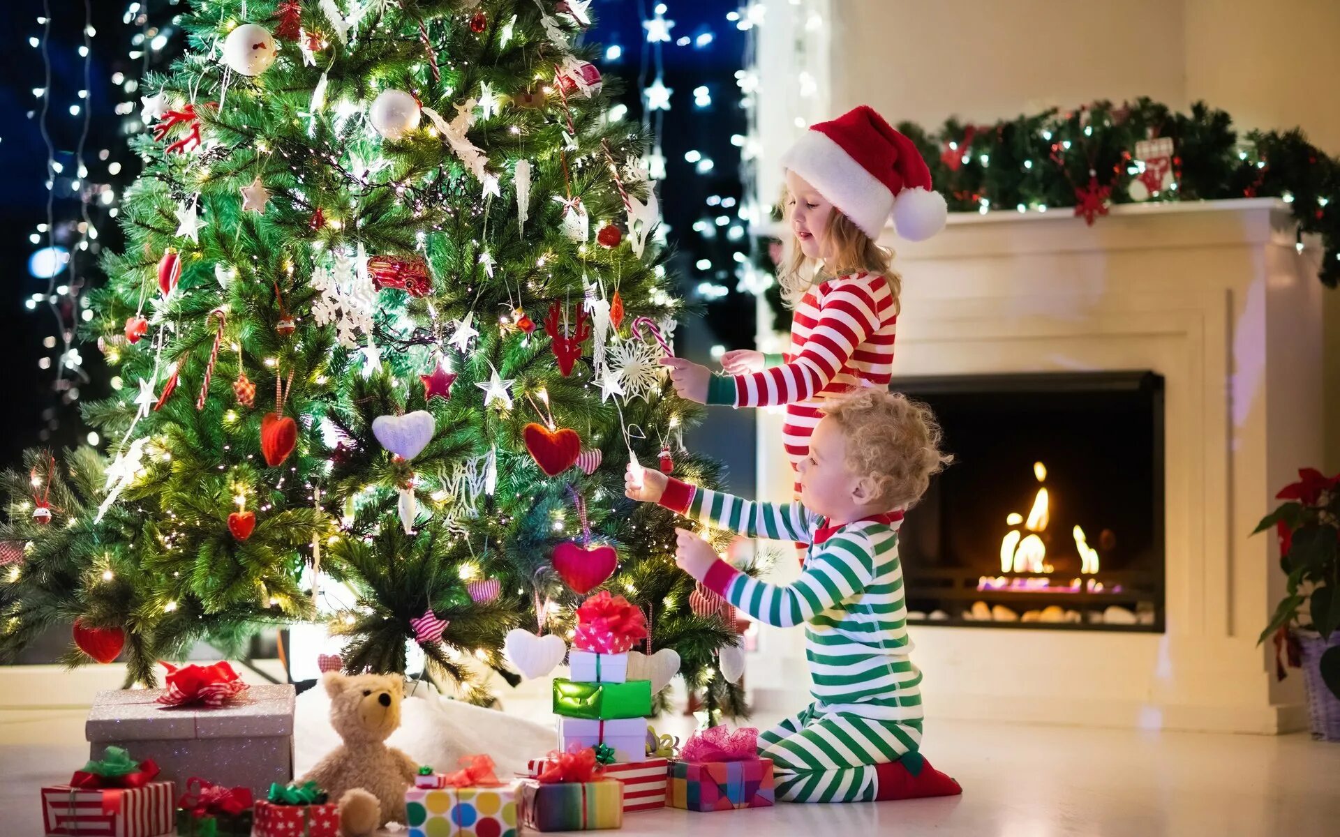 Рождество праздник детей. Елка Новогодняя украшенная. Подарки для елки. Дети наряжают елку. Красивая елка с подарками.